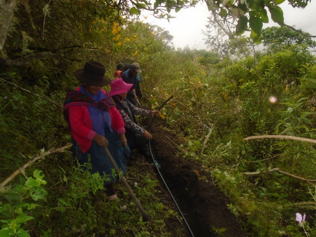 Mujeres y hombres trabajan en forma comunal en la conducción del agua con mangueras para el riego de sus sembradíos por el sistema de aspersión, y también para consumo humano, en el poblado de Oroncoy, en el altiplano de los Andes peruanos, integrado por unas 60 familias. Foto: Cortesía de Huñuc Mayu