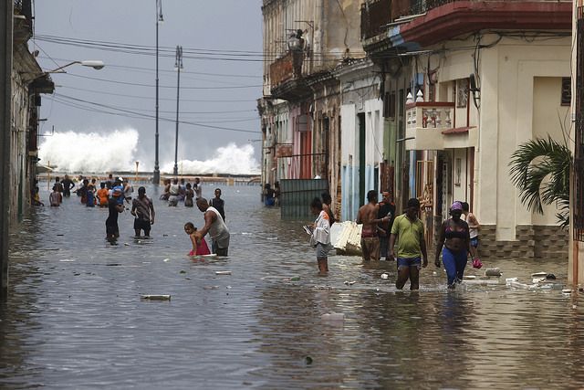 Residentes de La Habana transitan por una calle, transversal al malecón de la capital de Cuba, inundada por la embestida del mar tras el paso del huracán Irma, en septiembre de 2017. Foto: Jorge Luis Baños/IPS